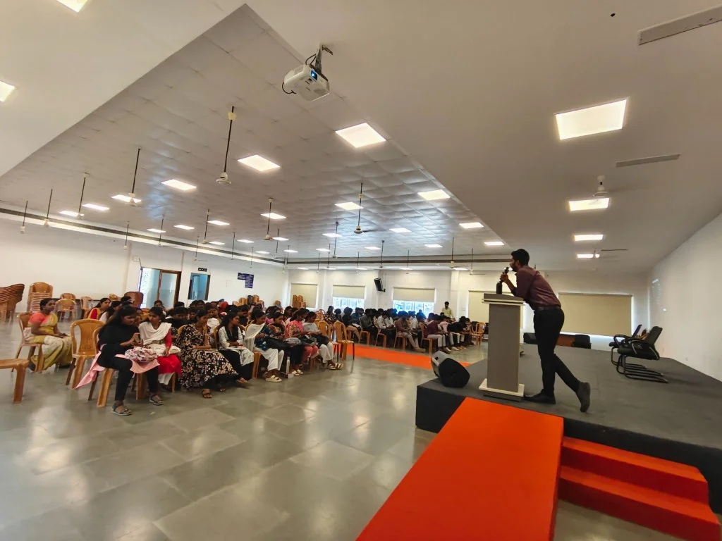 Large auditorium filled with students learning essential financial literacy concepts.